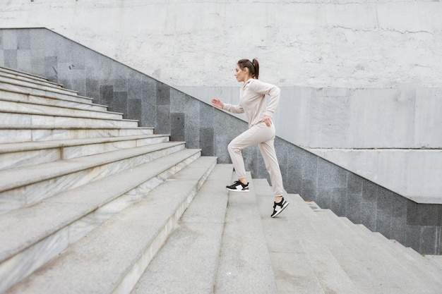 Estilo de vida saudável Mulher em forma de esportes subindo em escadas de pedra