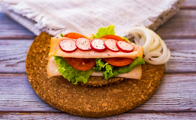 Foto estilo de vida saudável, sanduíche dietético com vegetais e carne de peru - alimentação saudável e saborosa - pão integral com sementes