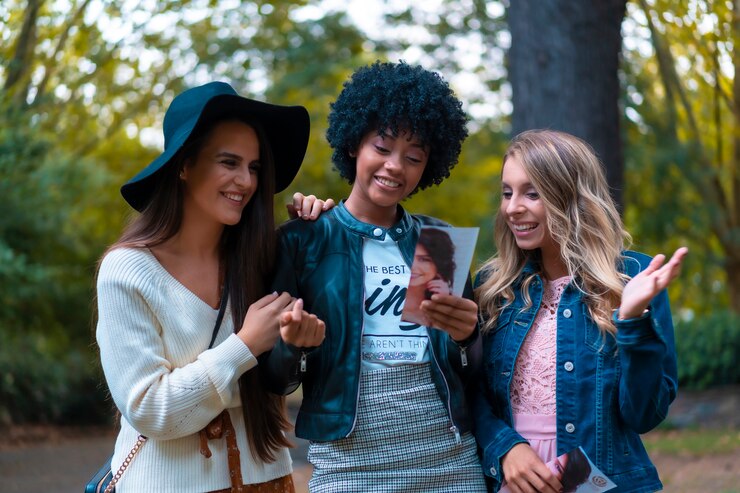 Foto estilo de vida. três amigas em um parque se divertindo, uma loira, uma morena e uma garota latina com cabelos afro