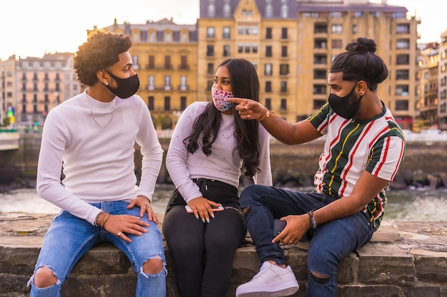 Estilo de vida, três amigos se divertindo na rua com responsabilidade social com máscaras faciais.