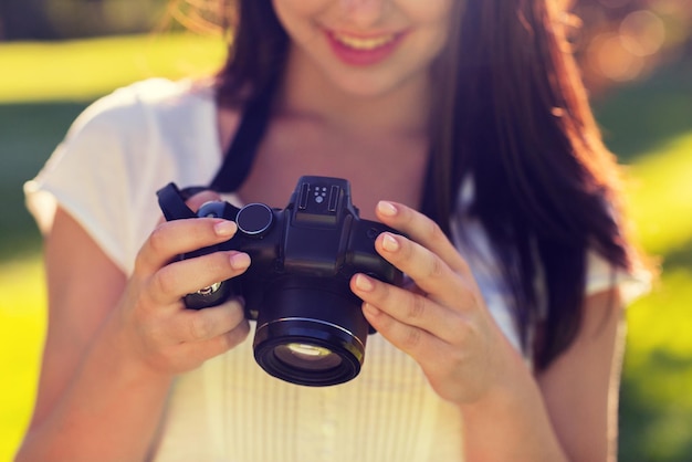 estilo de vida, verão, férias, tecnologia e conceito de pessoas - close-up de jovem com câmera fotográfica ao ar livre