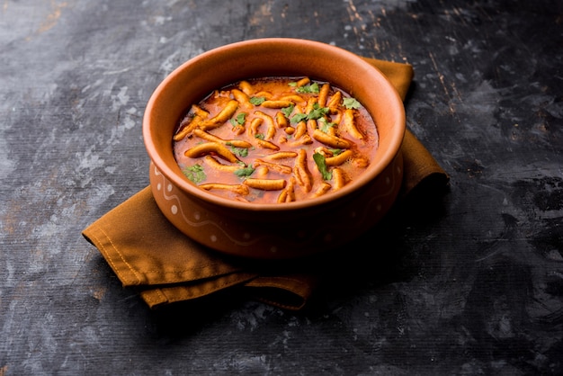 Estilo Dhaba Sev bhaji, sabzi, curry hecho en curry de tomate con gathiya o ganthia shev, servido en un cuenco o karahi, enfoque selectivo