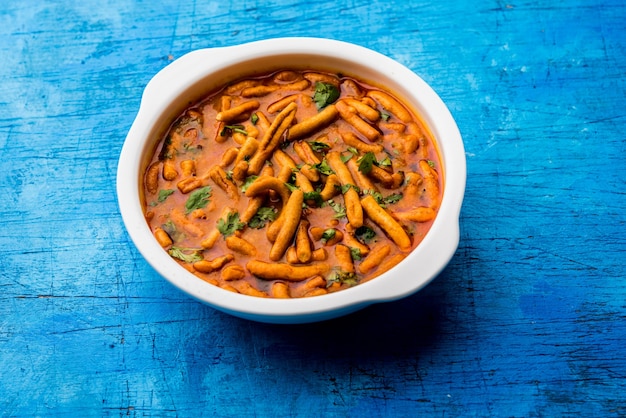 Estilo Dhaba Sev bhaji, sabzi, curry hecho en curry de tomate con gathiya o ganthia shev, servido en un cuenco o karahi, enfoque selectivo