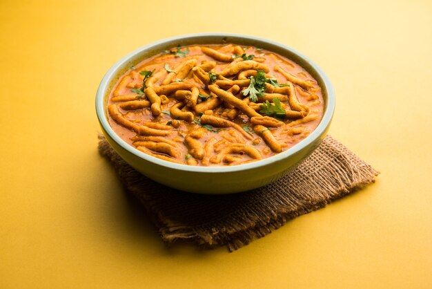 Foto estilo dhaba sev bhaji, sabzi, curry hecho en curry de tomate con gathiya o ganthia shev, servido en un cuenco o karahi, enfoque selectivo