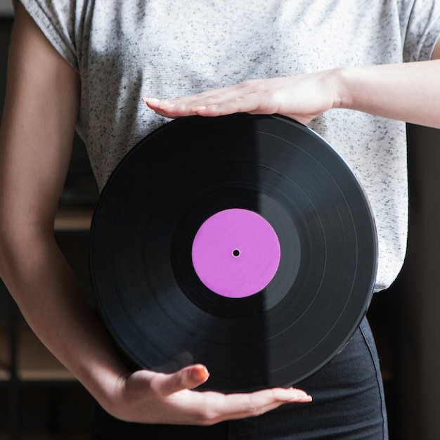 Estilo Dj. Fundo de discos de vinil. Estilo de vida jovem moderno, mulher irreconhecível, conceito de música