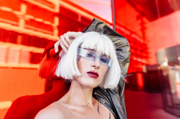 Estilo futurista. Mujer con gafas y cerca de un edificio futurista rojo.