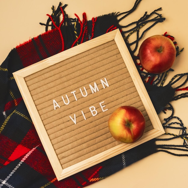 Estilo Hygge Flat Lay de otoño con bufanda de lana Manzanas rojas y tablero de letras con ambiente otoñal