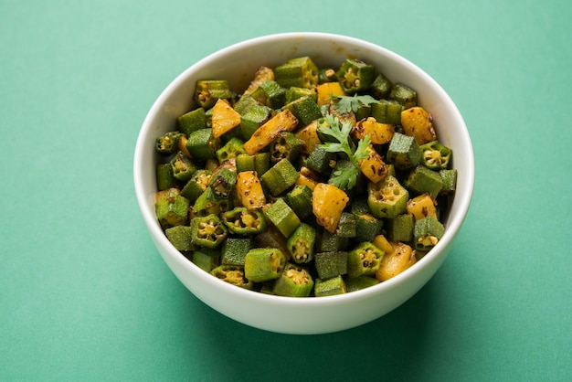 Estilo indiano Masala Sabji OU Sabzi de Bhindi frito OU quiabo, também conhecido como Ladyfinger, servido em uma tigela sobre fundo temperamental. foco seletivo