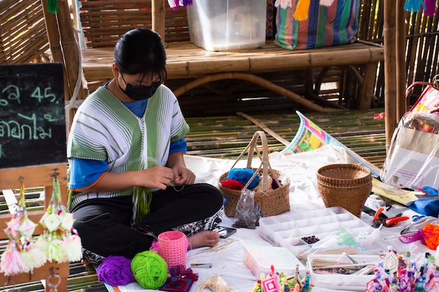 Estilo lanna de fio de tricô étnico de trabalho de Karen em loja de artesanato artesanal no mercado local de oh poi para o povo tailandês e visita de viagem para viajantes estrangeiros em Suan Phueng em 5 de novembro de 2022 em Ratchaburi, Tailândia