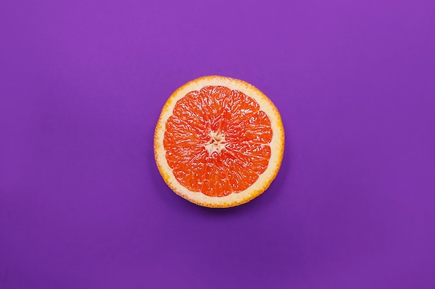 Estilo minimalista, diseño creativo de naranja y pomelo sobre fondo morado