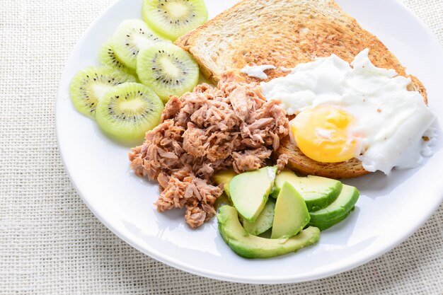 Estilo moderno alimentos limpos, pão, ovo, salada de atum, kiwi e abacate