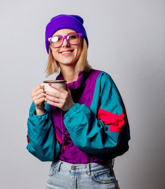 Estilo mujer en ropa punk de los 90 con taza de café