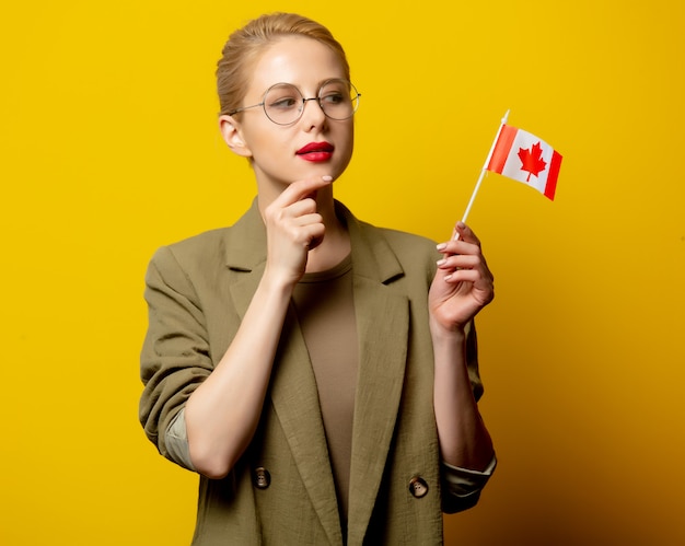 Estilo mujer rubia en chaqueta con bandera canadiense en amarillo