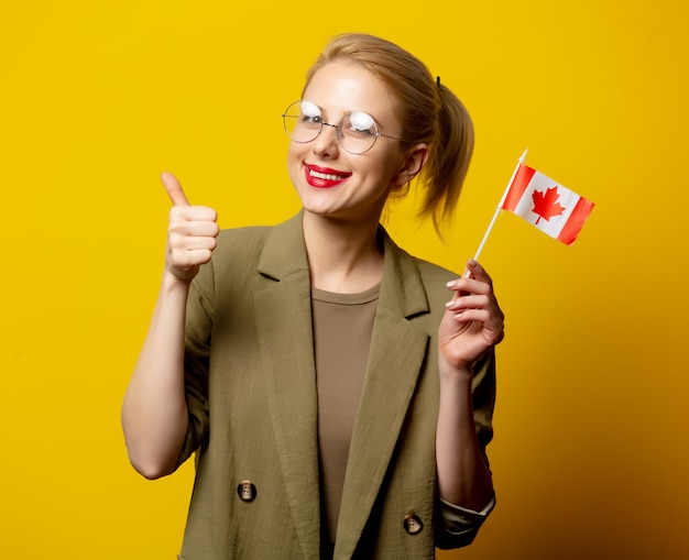 Estilo mujer rubia en chaqueta con bandera canadiense en amarillo