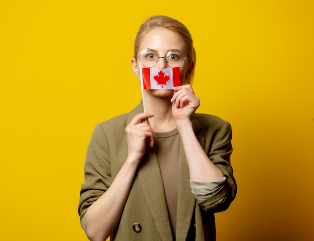 Estilo mujer rubia en chaqueta con bandera canadiense en amarillo