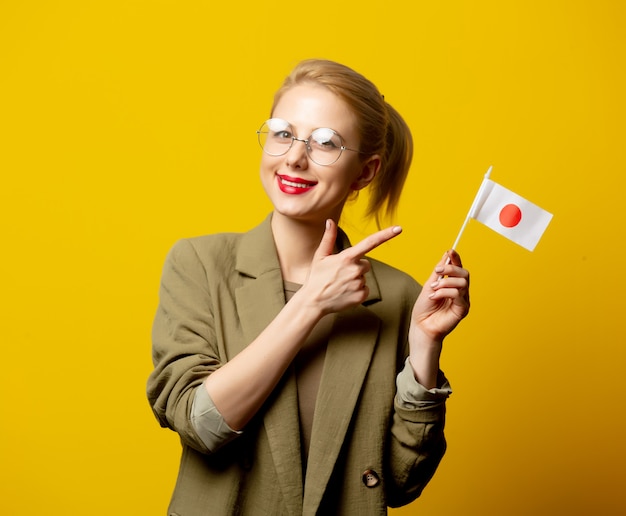 Estilo mujer rubia en chaqueta con bandera japonesa en amarillo