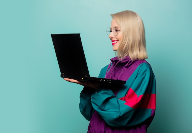 Estilo mujer rubia en gafas con ordenador portátil