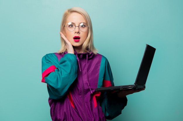 Estilo mujer rubia en gafas con ordenador portátil