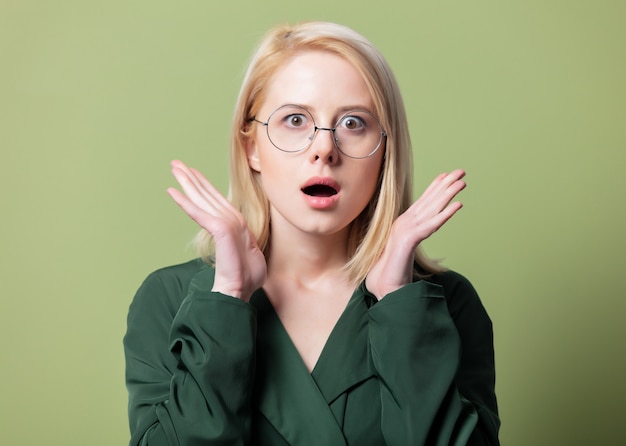 Estilo mujer rubia en manto y gafas redondas