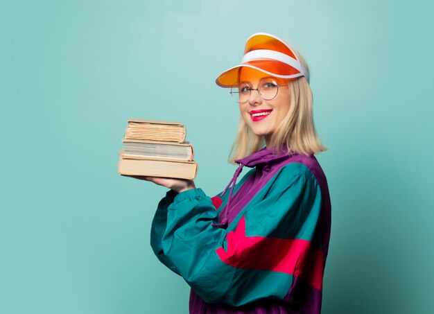 Estilo mujer rubia en traje deportivo de los años 90 con libros