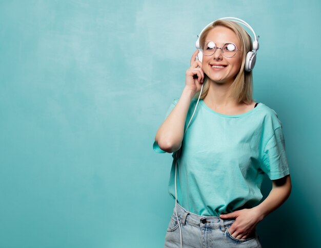 Estilo mulher loira de óculos com fones de ouvido