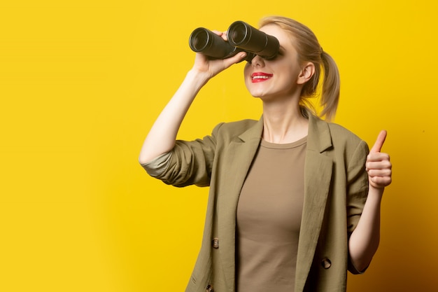 Estilo mulher loira na jaqueta com binóculos amarelo