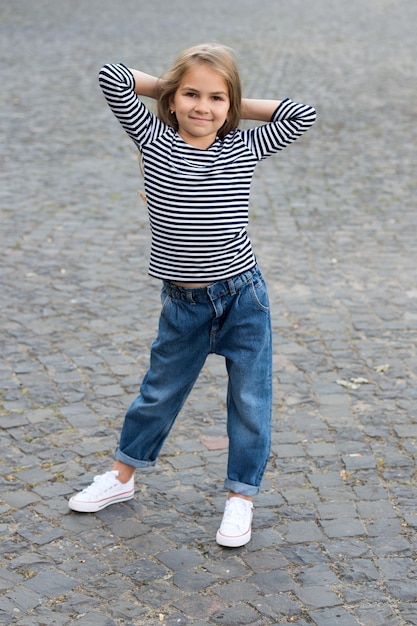 Estilo y postura que llaman la atención de todos. El niño pequeño usa un estilo casual al aire libre. Estilo de chica de moda. Tienda para bebés. Ropa de niños. Tendencia de moda. Diseño de moda. Armario de verano.