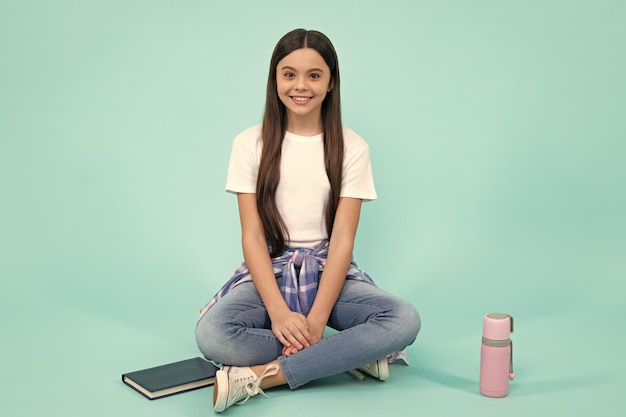 Foto estilo de vida adolescente chica adolescente deportiva con monopatín niño de moda en estilo moderno sobre fondo azul adolescente feliz emociones positivas y sonrientes de chica adolescente