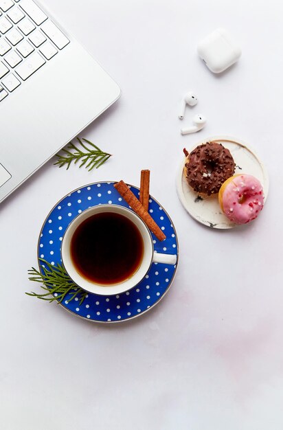 Estilo de vida con auriculares inalámbricos portátiles taza de café con donuts Curso en línea aprender idiomas freelance Tomando seminarios web trabajo en línea escuchar música o audiolibro Estética hogareña acogedora