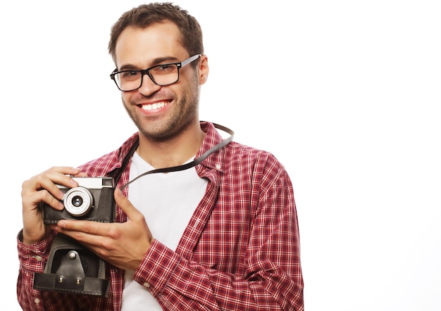 Estilo de vida y concepto de personas: joven con una cámara retro en un fondo blanco