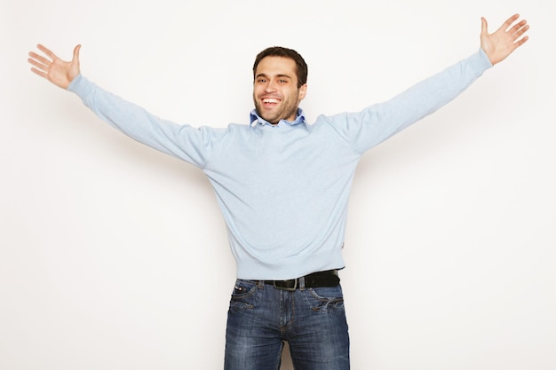 Estilo de vida y concepto de personas: joven casual en camisa con ambas manos levantadas en el aire. Ganador y feliz.