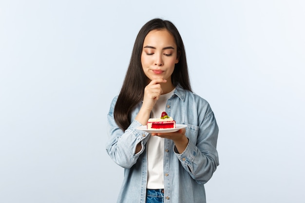 Estilo de vida de distanciamiento social, pandemia de covid-19, celebrando las vacaciones durante el concepto de coronavirus. Pensativa chica de b-día de aspecto serio pensando qué deseo hacer en el cumpleaños