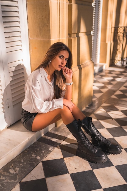 Estilo de vida una joven morena con una falda de cuero negro y una camisa blanca