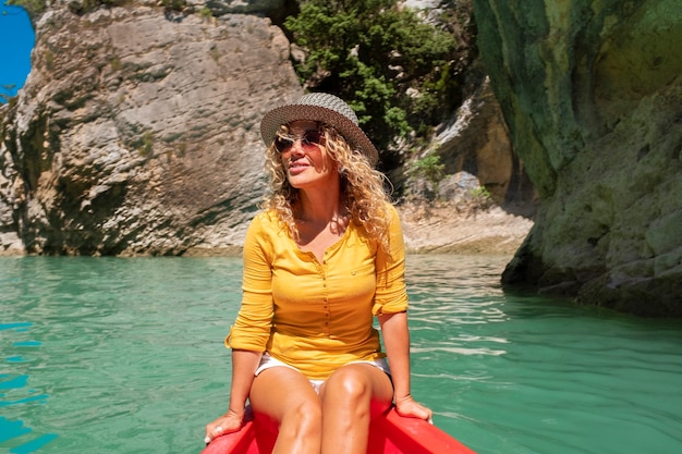 Estilo de vida de mujer viajero feliz sentado y disfrutando en una canoa roja en el hermoso cañón con río de agua verde - alegres mujeres libres se divierten en vacaciones y disfrutan de los viajes
