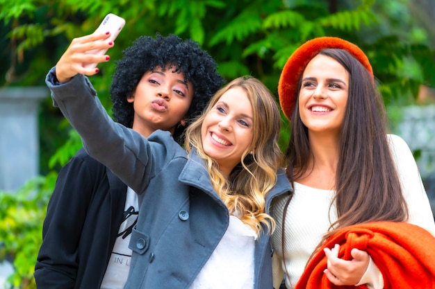 Foto estilo de vida multiétnico de tres novias tomando una foto selfie en la ciudad