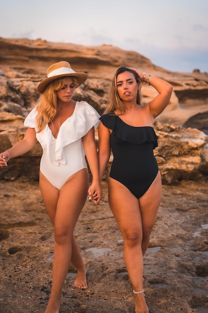 Estilo de vida de un par de chicas lesbianas caucásicas posando en la playa