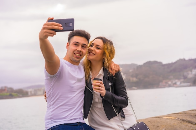 Estilo de vida de una pareja caucásica haciendo turismo y disfrutando de las vacaciones. Tomar una foto selfie con el teléfono móvil