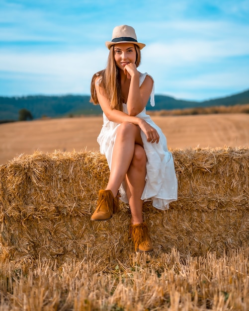 Estilo de vida rural, un joven agricultor rubio caucásico en vestido blanco sentado