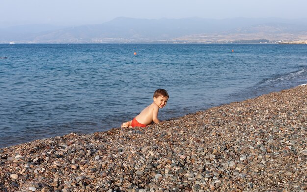 Estilo de vida saludable. Chico descansando y divirtiéndose en una playa rocosa en la costa mediterránea