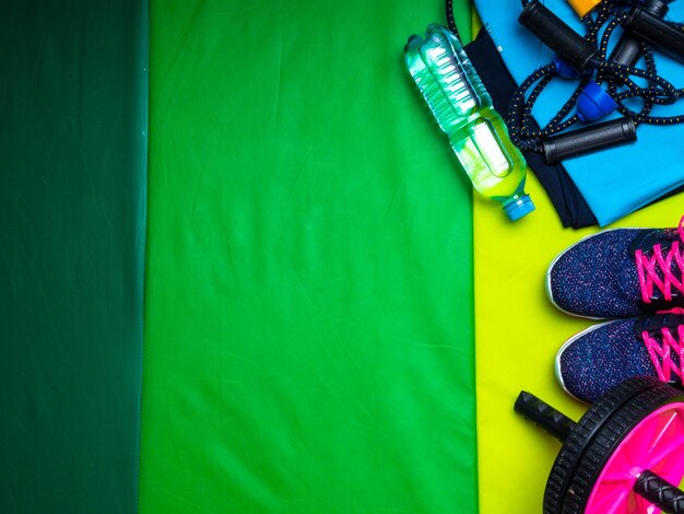 Estilo de vida saludable Deporte y nutrición saludable Vista superior del equipo deportivo zapatillas polainas camiseta estera verde deportes botella de agua Lay Flat