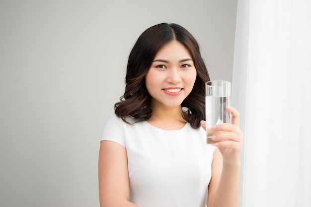 Estilo de vida saludable. Retrato de mujer joven sonriente feliz con vaso de agua dulce. Cuidado de la salud. Bebidas Salud, belleza, concepto de dieta. Alimentación saludable.