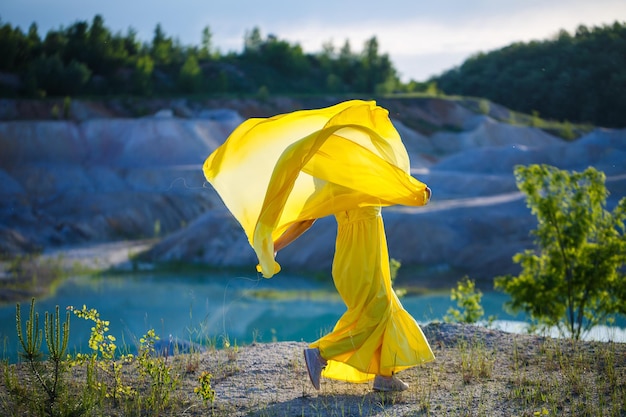 Estilo de vida de verano de impresionante mujer feliz corriendo en la naturaleza. Con un vestido amarillo largo. Estado de ánimo romántico. Disfrutando del sol. Día soleado. Enfoque selectivo