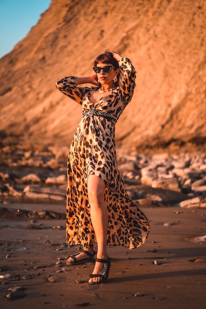 Estilo de vida de verano en una playa junto a las rocas de una joven morena caucásica