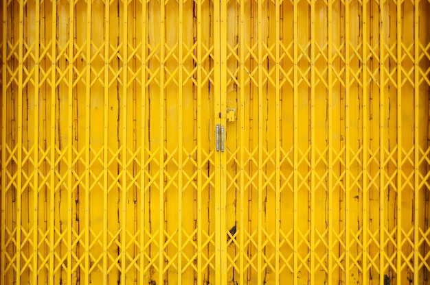 Estiramiento amarillo de la puerta de acero, estilo del vintage de la puerta de acero cercana.