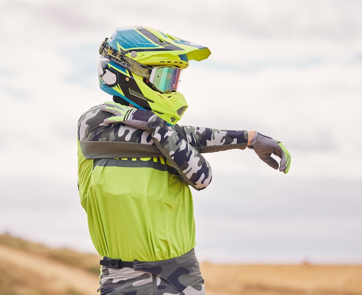 Foto estiramiento de deportes de motor y hombre con casco en la naturaleza para entrenamiento y rendimiento para carreras moto de viaje y persona al aire libre lista para la acción para la aventura, la libertad y la adrenalina