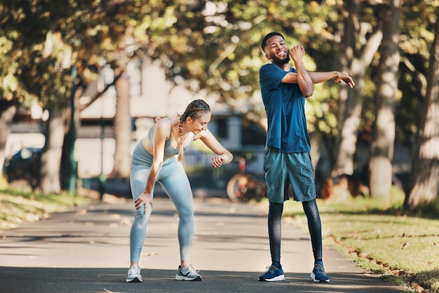 Estiramiento físico y descanso en pareja en el parque después de hacer ejercicio y hacer ejercicio juntos en la ciudad Bienestar de la salud y pareja interracial y hacer deportes de entrenamiento y comprobar el tiempo de rendimiento