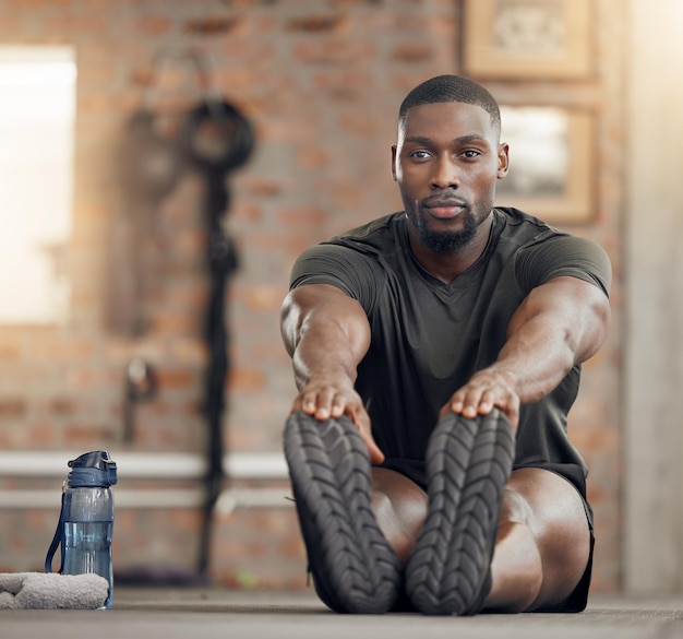 Estiramiento y fitness de hombre negro en entrenamiento de gimnasia y ejercicio con objetivos de salud motivación o objetivo de bienestar Atleta deportivo culturista o entrenador personal en calentamiento para alivio muscular