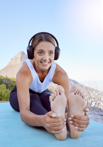 Estiramiento de yoga al aire libre y mujer con auriculares escuchando podcast de bienestar o música tranquila para motivar el ejercicio Deportista en entrenamiento de cardio o pilates con audio en la naturaleza y destello de lente