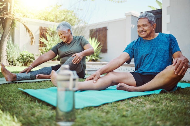 Foto estiramiento de yoga y ejercicios de bienestar y fitness para parejas mayores para perder peso o salud para la jubilación jardín trasero y ancianos felices o amigos con pilates o entrenamiento al aire libre