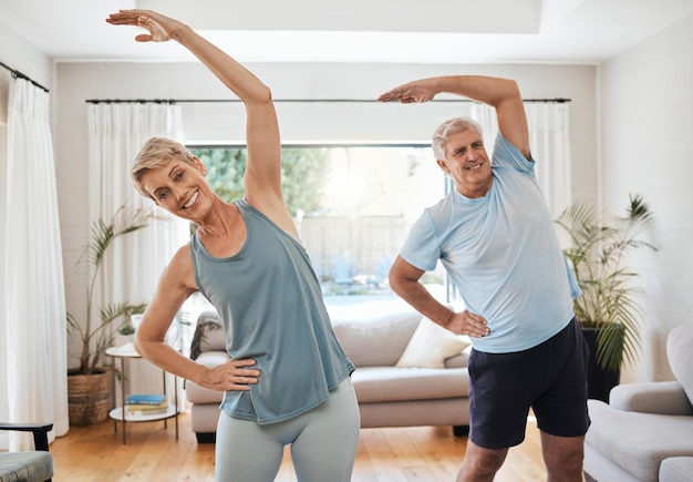 Estiramiento de yoga y fitness con una pareja mayor haciendo ejercicio o entrenando en casa Estilo de vida de salud y bienestar y activo con un anciano y una mujer en forma haciendo ejercicio en una casa